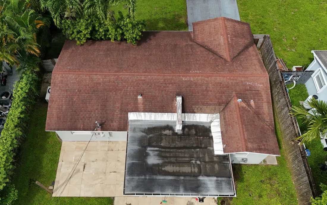 Drone view of a Florida home during a Secure Claims roof inspection, the stained flat section in the middle of the frame